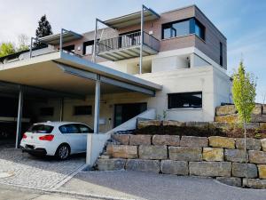 ein weißes Auto, das vor einem Haus parkt in der Unterkunft Hengnau 46, Ferienwohnung Stiefel in Wasserburg + 7 Fotos