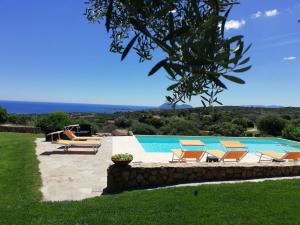 a swimming pool with lounge chairs and a swimming pool at La Sima villa con piscina vista mare San Pantaleo Sardegna in San Pantaleo