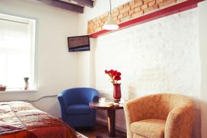 a bedroom with a bed and a chair and a table at Lvovo Apartments in Vilnius