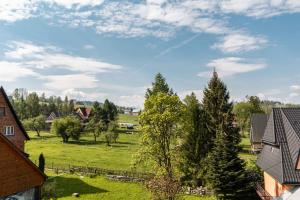 GrońにあるGronikの木々や家々が茂る畑の景色