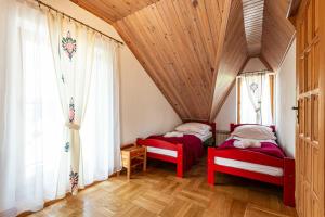 two beds in a room with a wooden ceiling at Gronik in Groń