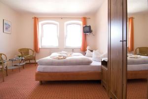 een slaapkamer met 2 bedden en een raam bij Gasthaus & Pension St.Peter in Eisenach
