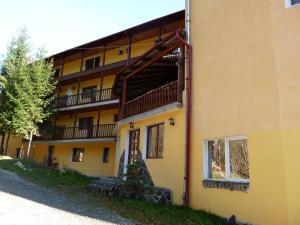a yellow building with a staircase on the side of it at Vila Transilvania in Balvanyos