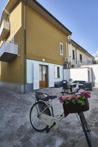 una bicicleta estacionada fuera de un edificio con flores en una cesta en ZENZERO E CANNELLA, en Empoli