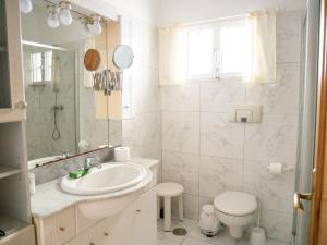 a white bathroom with a sink and a toilet at Monte Rojo in Corralejo