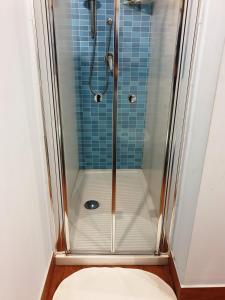 una doccia con porta in vetro in bagno di La casetta di Tilde a Termini Imerese