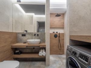 a bathroom with a sink and a washing machine at Loft House Premium Apartments in Wrocław