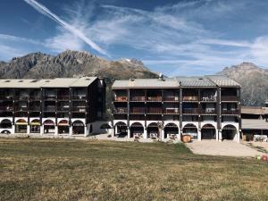 a large building with mountains in the background at Appartement Au Pied Des Pistes in Puy-Saint-Vincent