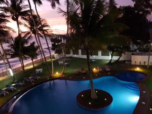 una vista aérea de una piscina con palmeras y sillas en Résidence Hôtelière Océane, en Libreville