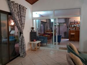d'un salon avec des portes coulissantes en verre et une table. dans l'établissement Résidence Hôtelière Océane, à Libreville