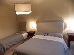 two beds in a small room with two lamps at B&B Nonna Rosa in Norcia