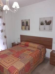 ein Schlafzimmer mit einem Bett mit einer farbenfrohen Tagesdecke in der Unterkunft 29 Calle Cártama in La Cala de Mijas