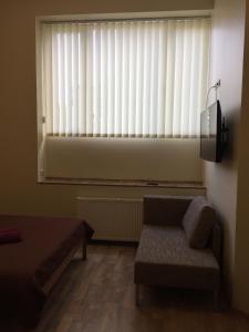 a living room with a couch and a window with blinds at Cat Garden Premium Apartments Riga in Rīga