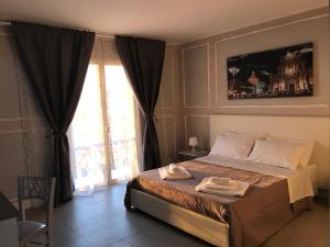a bedroom with a large bed and a large window at Borgo Palombaio in Catania