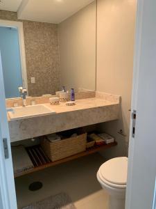 a bathroom with a sink and a toilet at Apartamento lazer na rua da praia in Riviera de São Lourenço +14 photos