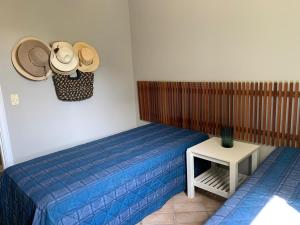 a bedroom with two beds and hats on the wall at Apartamento lazer na rua da praia in Riviera de São Lourenço