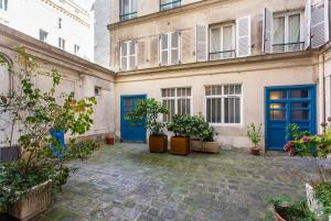 un patio de un edificio con puertas azules en Dreamyflat - loft opera, en París