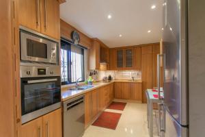 een keuken met houten kasten en een roestvrijstalen koelkast bij 4 bedroom apartment close by beach in Fuengirola in Fuengirola