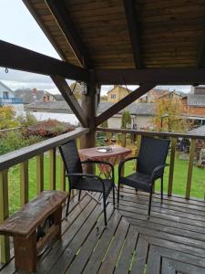 a wooden deck with a table and chairs and a bench at GARDEN CHALET in Daugavpils
