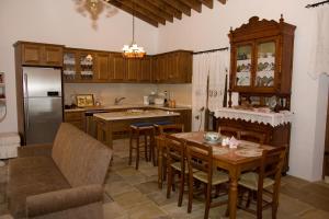 a kitchen with a table and chairs and a refrigerator at Xenios Cottages in Lofou
