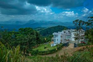 ein Haus auf einem Hügel mit Bergen im Hintergrund in der Unterkunft Villa Vajrapani in Kandy