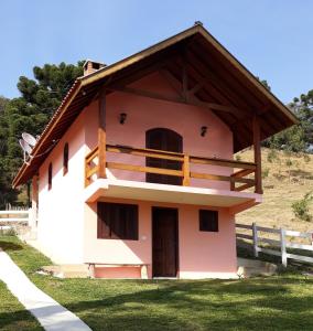 a small pink building with a wooden roof at Aconchego em Minas - Goncalves -Bairro Costas in Gonçalves