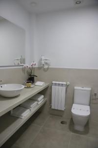 a white bathroom with a sink and a toilet at Aires do Umia in Caldas de Reis