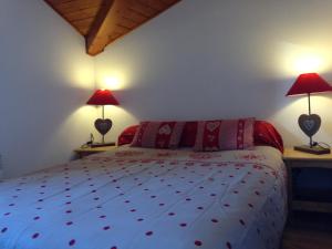 sypialnia z łóżkiem z czerwonymi poduszkami i 2 lampami w obiekcie Eden sur les pistes avec vue panoramique sur la vallée w mieście La Joue du Loup
