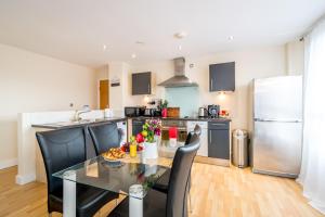 a kitchen with a table and chairs and a refrigerator at Spacious City 2 Bed, 2 Bath, FREE PARKING & WiFi in Sheffield