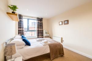 a bedroom with a bed and a window at Spacious City 2 Bed, 2 Bath, FREE PARKING & WiFi in Sheffield