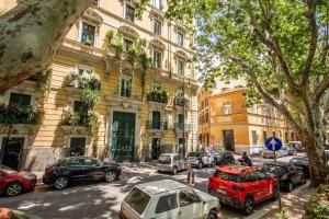 ulica z samochodami zaparkowanymi przed budynkiem w obiekcie Ripetta Miracle Suite w Rzymie