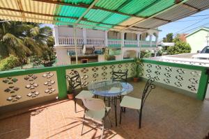 a patio with a glass table and chairs on a balcony at Rainforest Haven Inn in San Ignacio