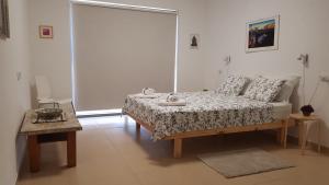 a bedroom with a bed and a table and a window at The Shining Star -A beautiful 3 bedroom apartment in Beer Sheva