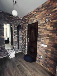 a room with a door and a brick wall at Apartment Selena in Baranavichy