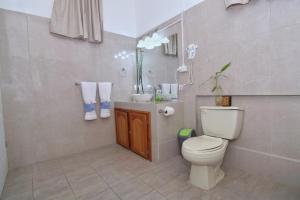 a bathroom with a toilet and a sink at Rainforest Haven Inn in San Ignacio