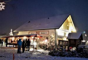 um grupo de pessoas em pé fora de uma loja na neve em Apartmaji Štrud´l Bohinj em Bohinj