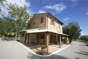 a large brick building with a patio in front of it at Villa Podere S. Gaetano in Chiusi