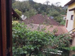 a window with a view of a garden at Pousada Canteiros de São Pedro da Serra-Nova Friburgo in São Pedro da Serra