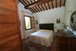 Schlafzimmer mit einem Bett, einer Kommode und einem Spiegel in der Unterkunft Villa Podere S. Gaetano in Chiusi