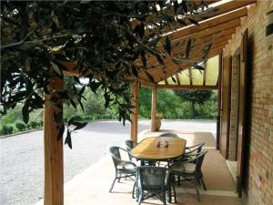 einen Holztisch und Stühle auf einer Terrasse in der Unterkunft Villa Podere S. Gaetano in Chiusi