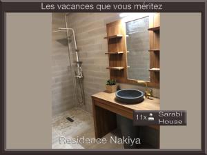 La salle de bains est pourvue d'un lavabo et d'une douche. dans l'établissement Résidence Nakiya, à Sainte-Marie