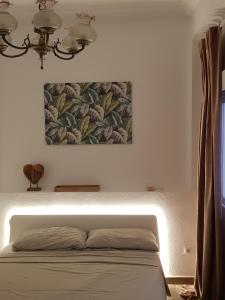 a bedroom with a bed with a painting on the wall at Immaculada Apartament Gandia in Gandía