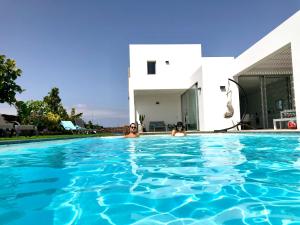 twee personen in een zwembad voor een huis bij Turquesa 2 Fuerteventura in Lajares