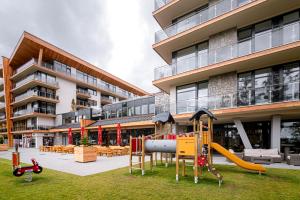 a playground in front of a building at Apartment Elegance Hrebienok in Smokovce