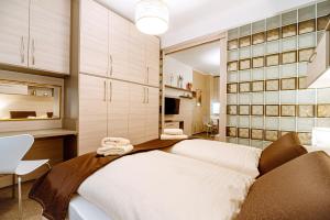 a bedroom with two beds and a television in a room at Apartment Elegance Hrebienok in Smokovce