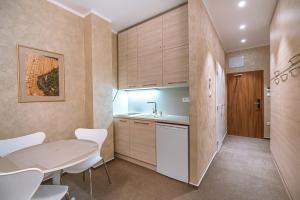 a kitchen with a table and white chairs at Apartment Elegance Hrebienok in Smokovce