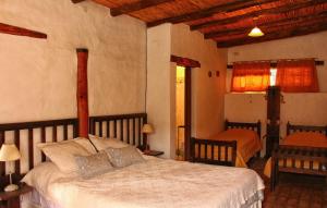 a bedroom with a large bed and two chairs at Huaira Huasi in Purmamarca