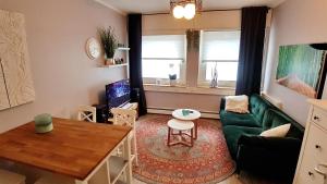 uma sala de estar com um sofá verde e uma mesa em Apartment Weinsberg em Colónia