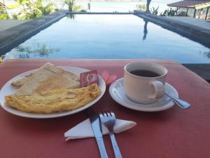 une assiette de nourriture et une tasse de café sur une table dans l'établissement Kusuma Lembongan by ABM, à Nusa Lembongan