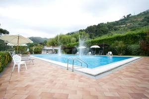 a swimming pool with a fountain in a yard at Grappolo D'Oro in Pietrasanta